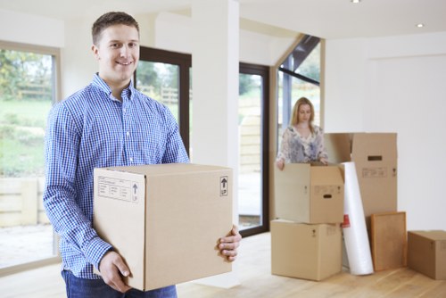 Local movers carrying boxes from a Brent flat with stairs