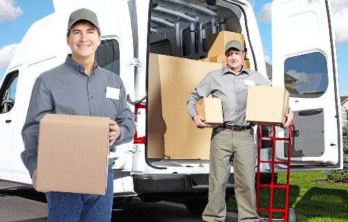 Packed moving boxes and furniture ready for transport in Brent